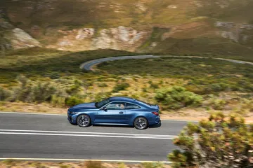 BMW Serie 4 mostrando su perfil lateral en una carretera de montaña.