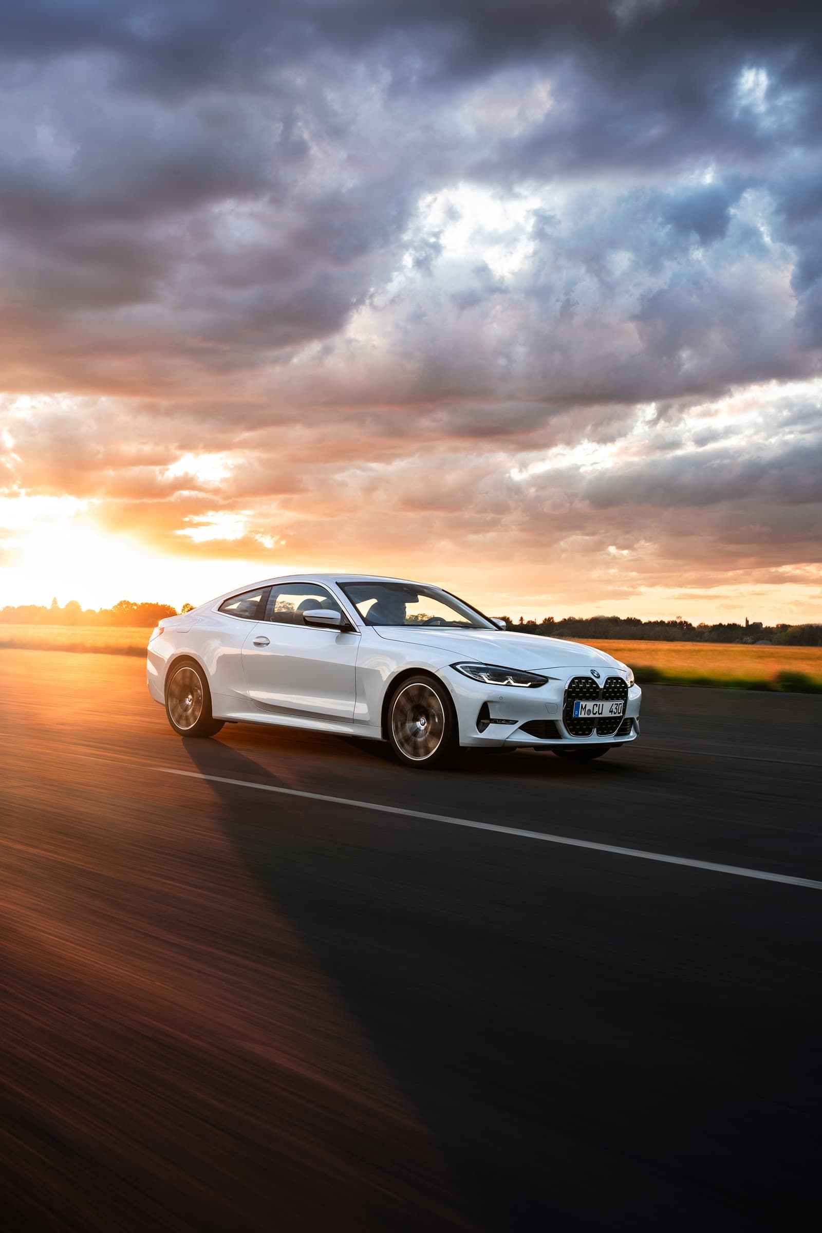 Imagen en movimiento del BMW Serie 4 captando su silueta lateral al atardecer.