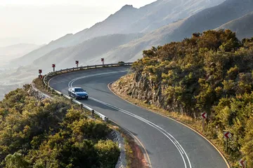 BMW Serie 4 deslizándose por carreteras serpenteantes con paisaje montañoso de fondo