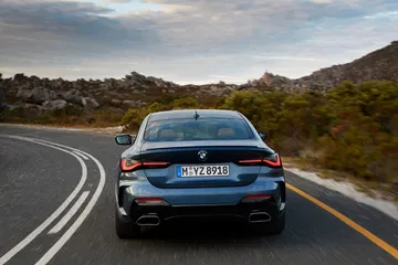 Vista trasera del BMW Serie 4 en carretera, destacando sus líneas y ópticas.