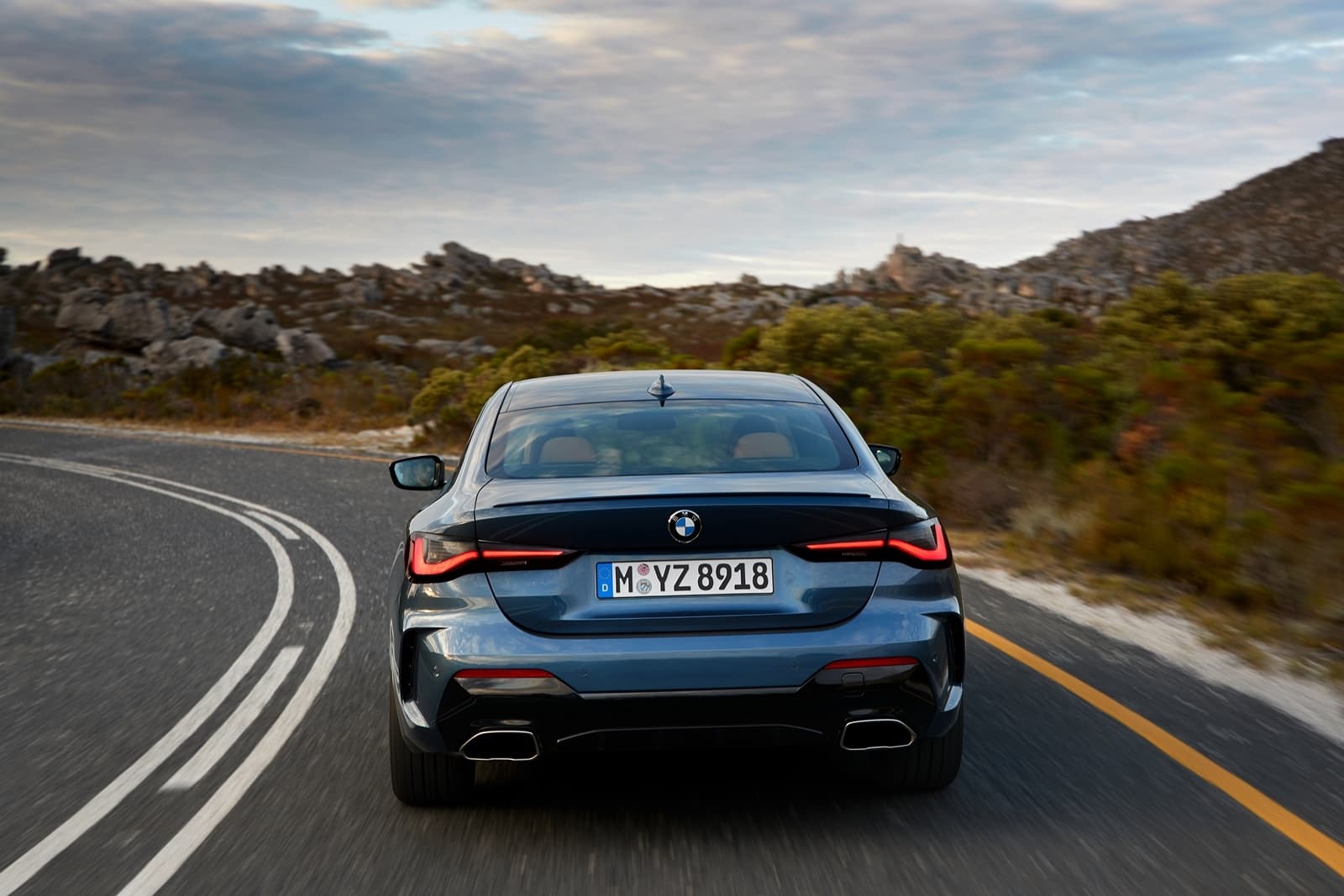 Vista trasera del BMW Serie 4 en carretera, destacando sus líneas y ópticas.