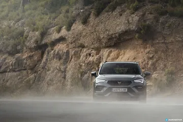 Vista lateral del CUPRA Ateca en plena acción en carretera.