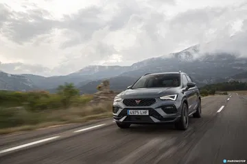 Vista dinámica del CUPRA Ateca en acción, destacando su frontal y línea lateral.