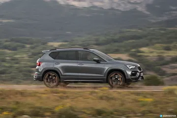 Vista lateral del CUPRA Ateca mostrando su perfil deportivo sobre terreno montañoso.