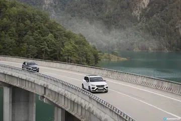 Vista dinámica del CUPRA Ateca recorriendo un puente con paisaje montañoso.