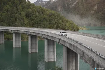 Vista lateral del CUPRA Ateca cruzando un moderno puente de hormigón.