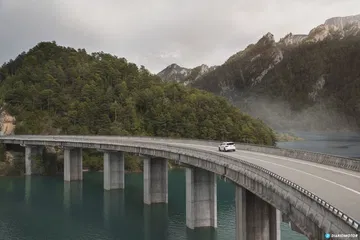 Vista lateral del CUPRA Ateca cruzando un imponente puente en montaña.