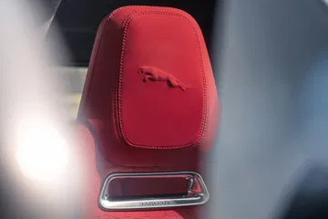Vista de cerca del cabecero con el emblema de Jaguar, en rojo.