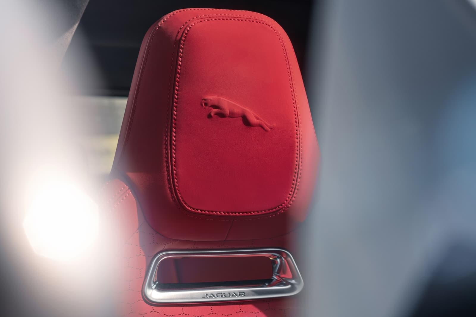 Vista de cerca del cabecero con el emblema de Jaguar, en rojo.