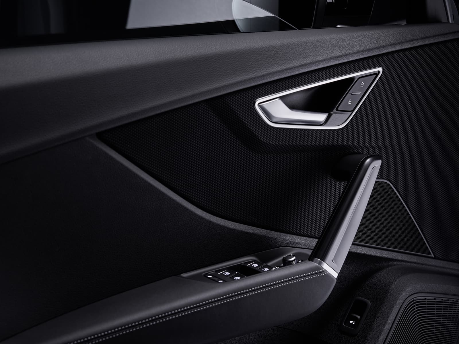 Vista cercana del acabado y controles en la puerta del Audi Q2, resaltando su diseño y calidad.