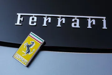 Primer plano del icónico emblema de Ferrari sobre fondo oscuro.