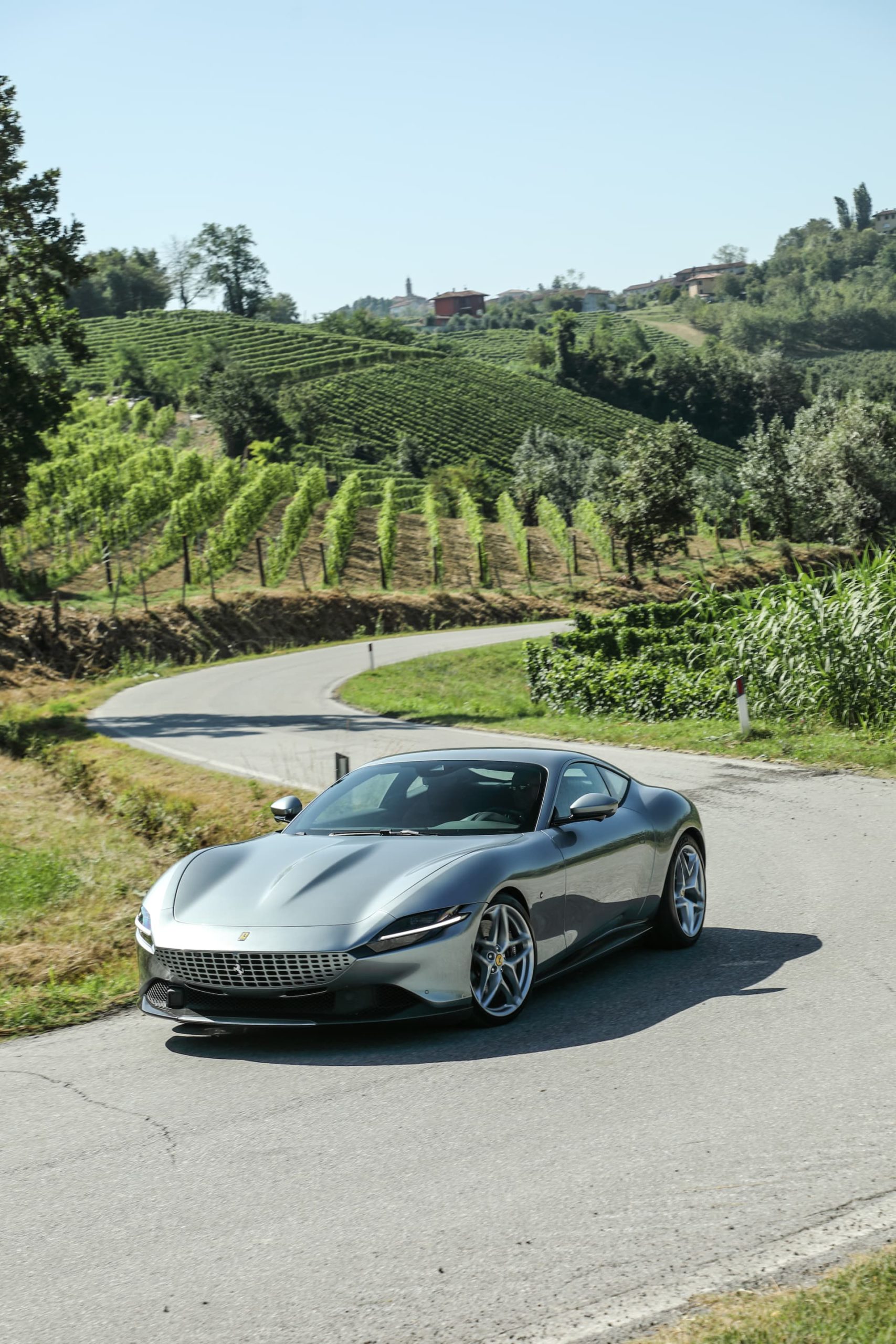 Ferrari Roma en carretera con diseño frontal elegante y perfil dinámico.