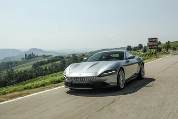 Vista frontal y lateral del Ferrari Roma con un paisaje natural de fondo