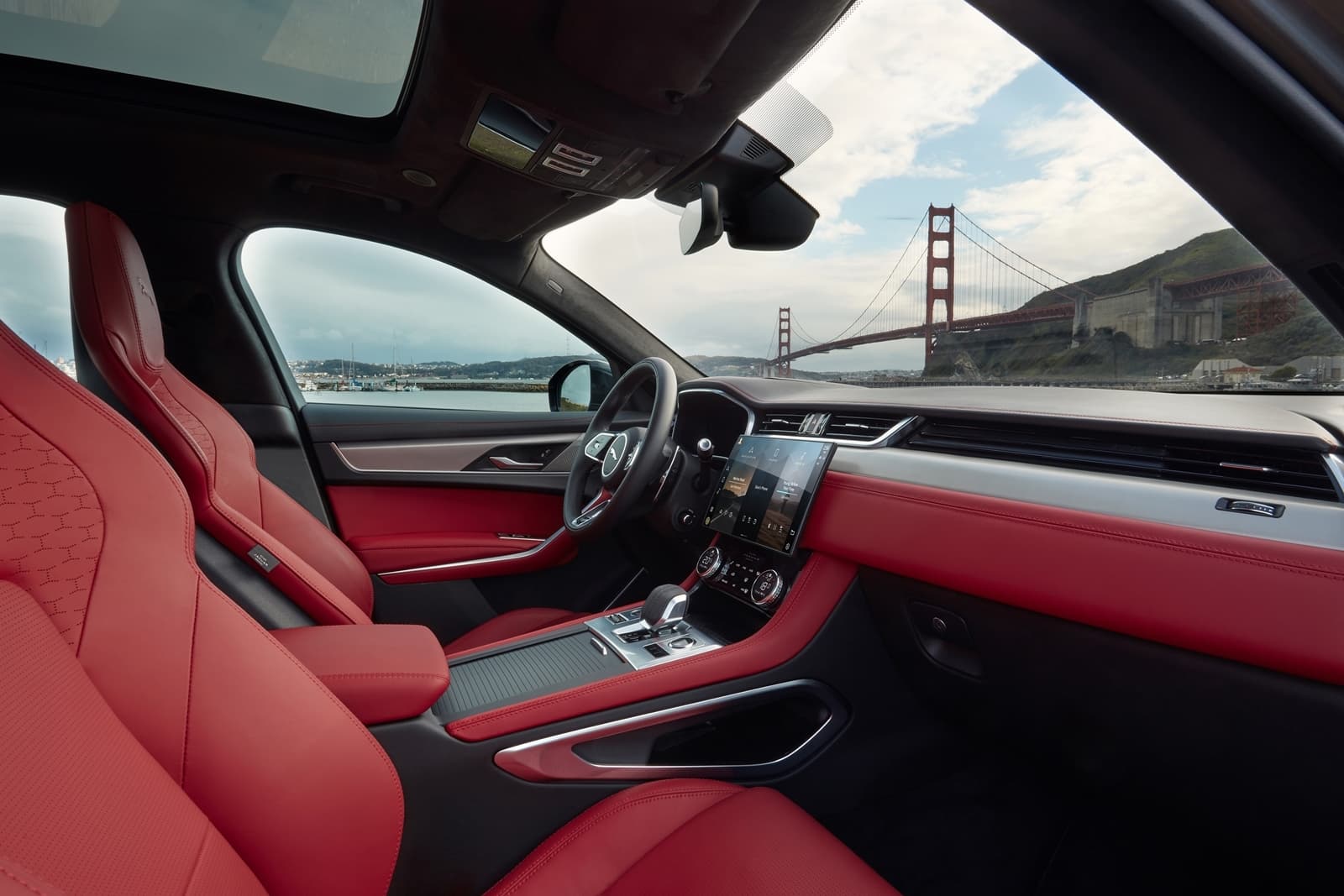 Vista lateral interna destacando la elegancia de los asientos rojos del Jaguar F-PACE.