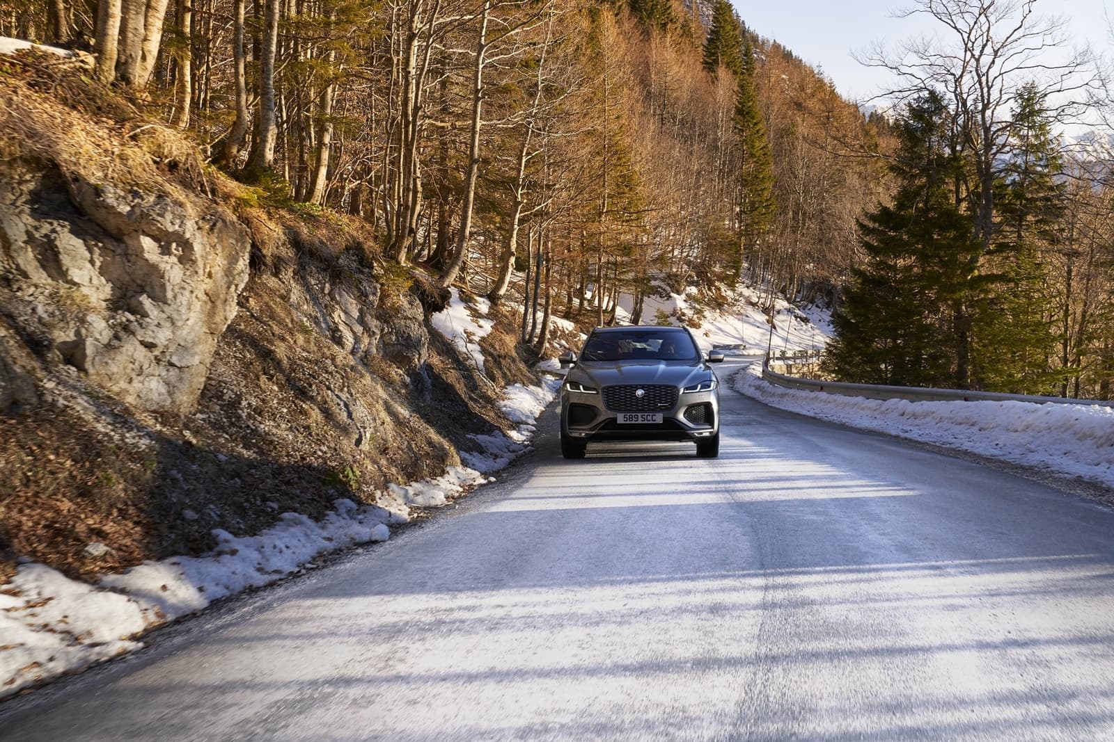 Jaguar F-PACE en carretera invernal mostrando su estilizada figura y robustez.