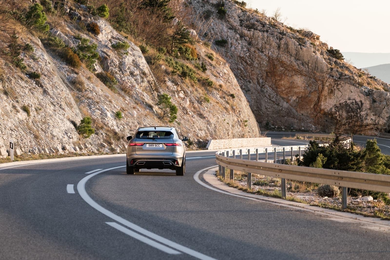 Vista dinámica del Jaguar F-PACE abordando una curva en carretera de montaña.