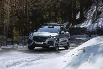 Vista dinámica del Jaguar F-PACE en carretera nevada.
