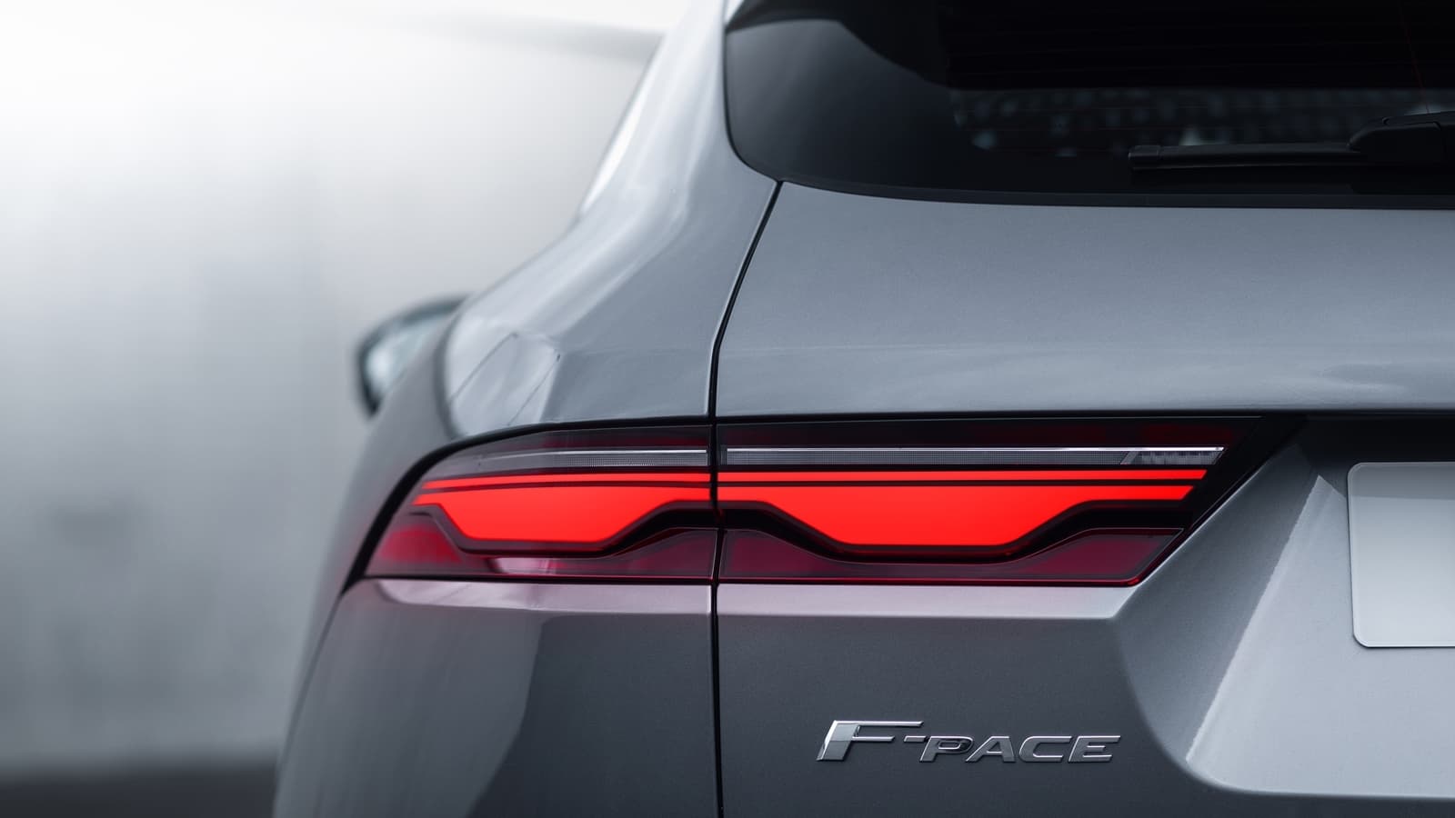 Vista detallada de las luces traseras y insignia F-PACE.