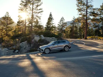 Vista lateral del Jaguar F-PACE en un entorno natural, destacando su diseño aerodinámico.
