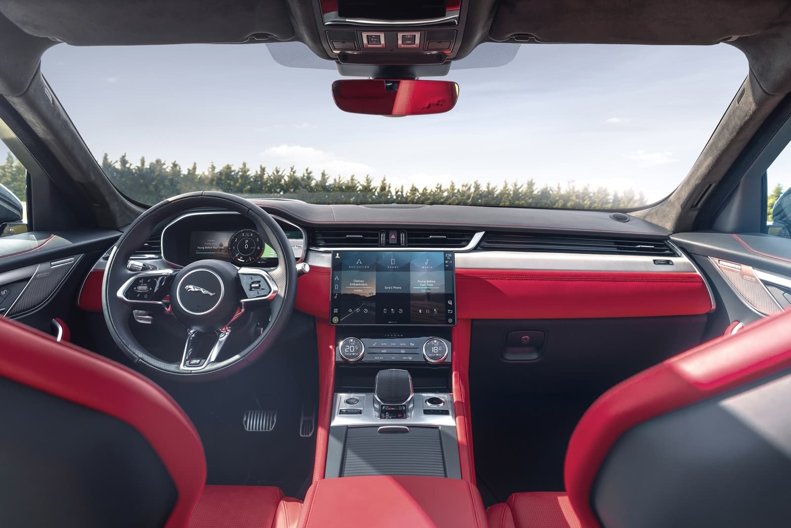 Cabina delantera del Jaguar F-PACE con tapicería roja y negra y volante multifunción.