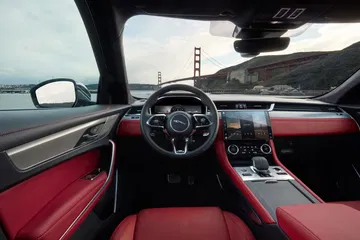 Vista del volante y consola central en tonos rojos del Jaguar F-PACE.