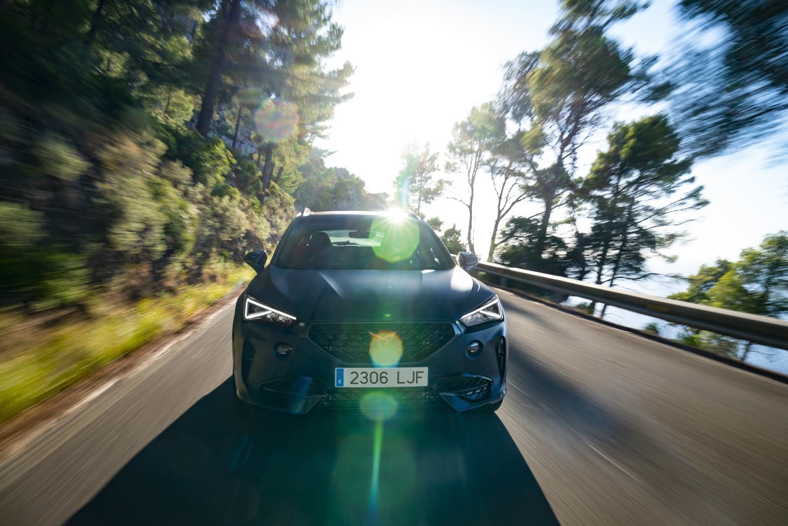 Vista frontal del CUPRA Formentor en movimiento sobre un camino arbolado.