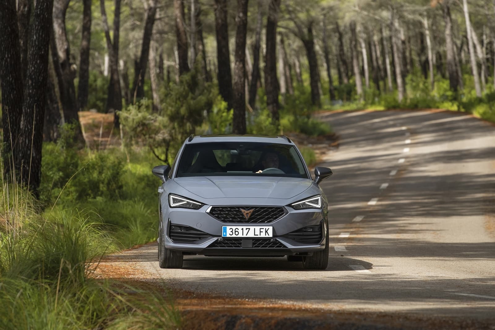 Vista delantera del CUPRA León en movimiento, destacando su dinamismo y diseño frontal.