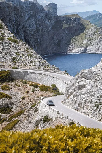 CUPRA León desplegando su elegancia en una carretera de montaña serpenteante.