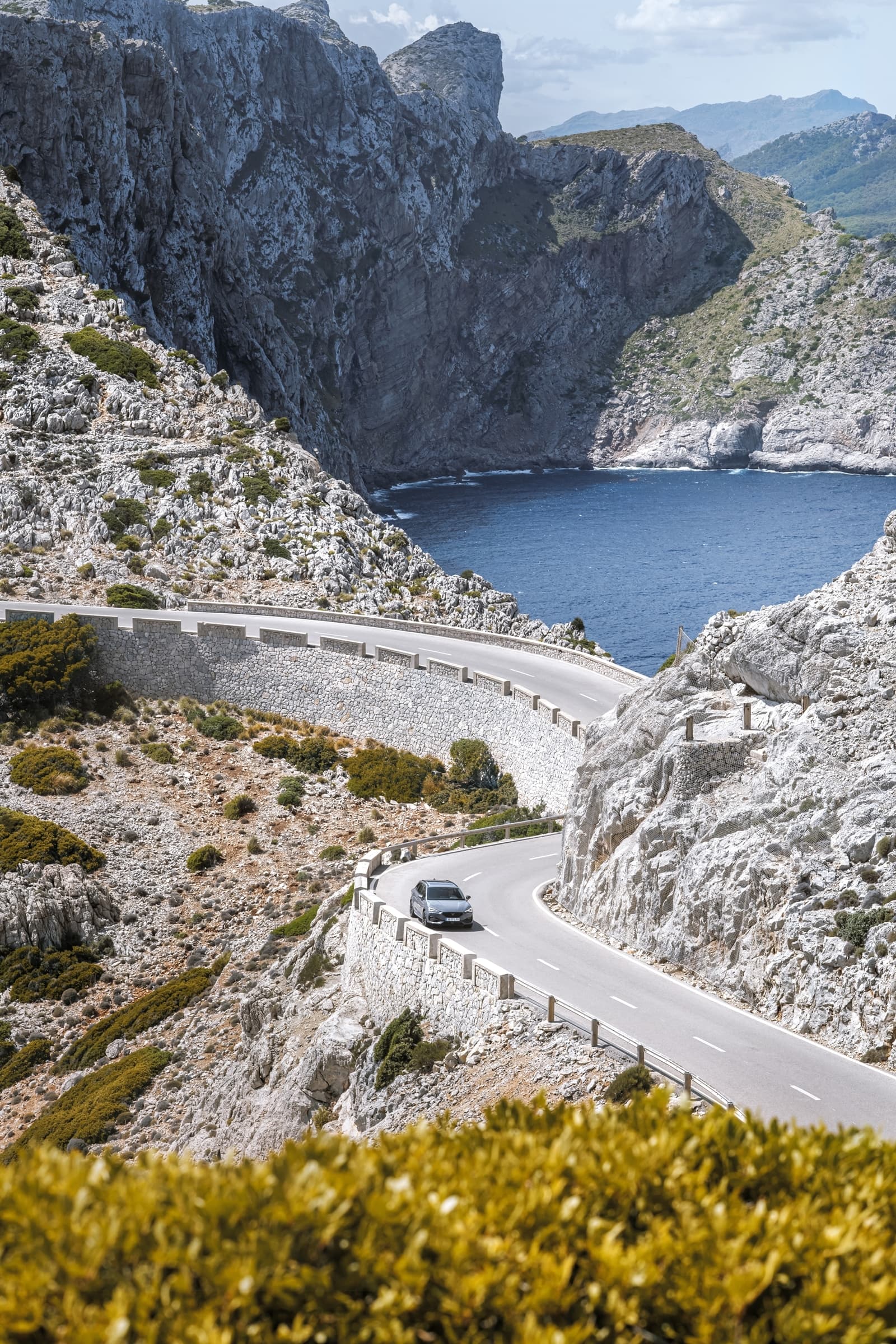 CUPRA León desplegando su elegancia en una carretera de montaña serpenteante.