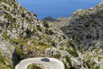 Vista lateral del CUPRA León dominando curvas en entorno montañoso