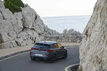 Vista trasera del CUPRA León serpentenado en carreteras de montaña.