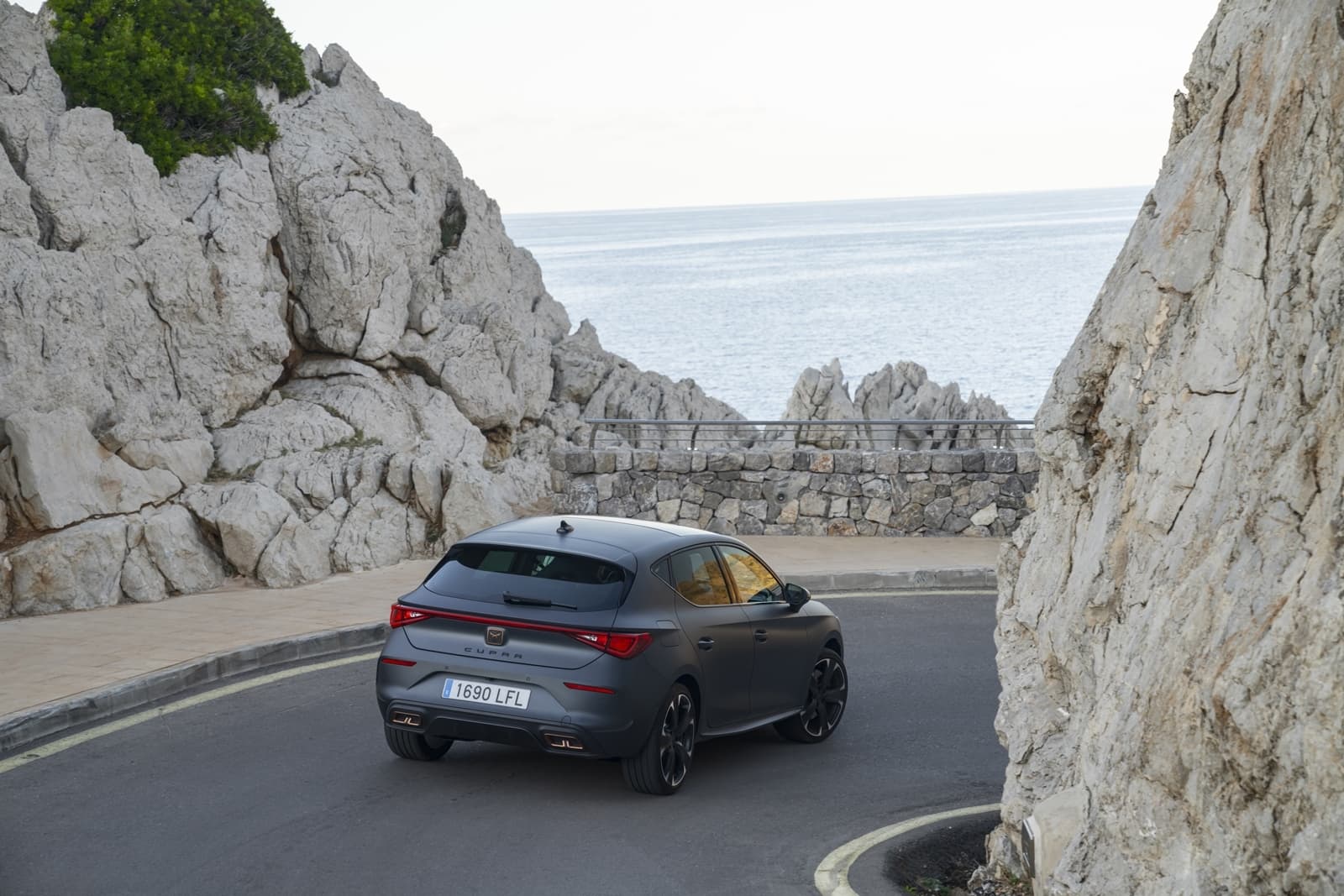Vista trasera del CUPRA León serpentenado en carreteras de montaña.