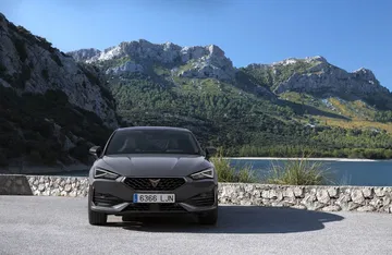 Vista frontal del CUPRA León con imponente paisaje montañoso al fondo.