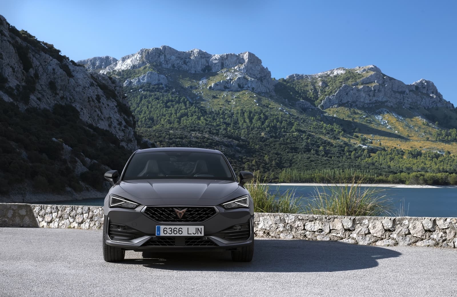 Vista frontal del CUPRA León con imponente paisaje montañoso al fondo.