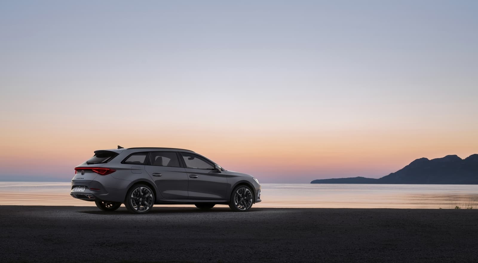 Vista lateral del CUPRA León con un atardecer de fondo, realzando su diseño dinámico.