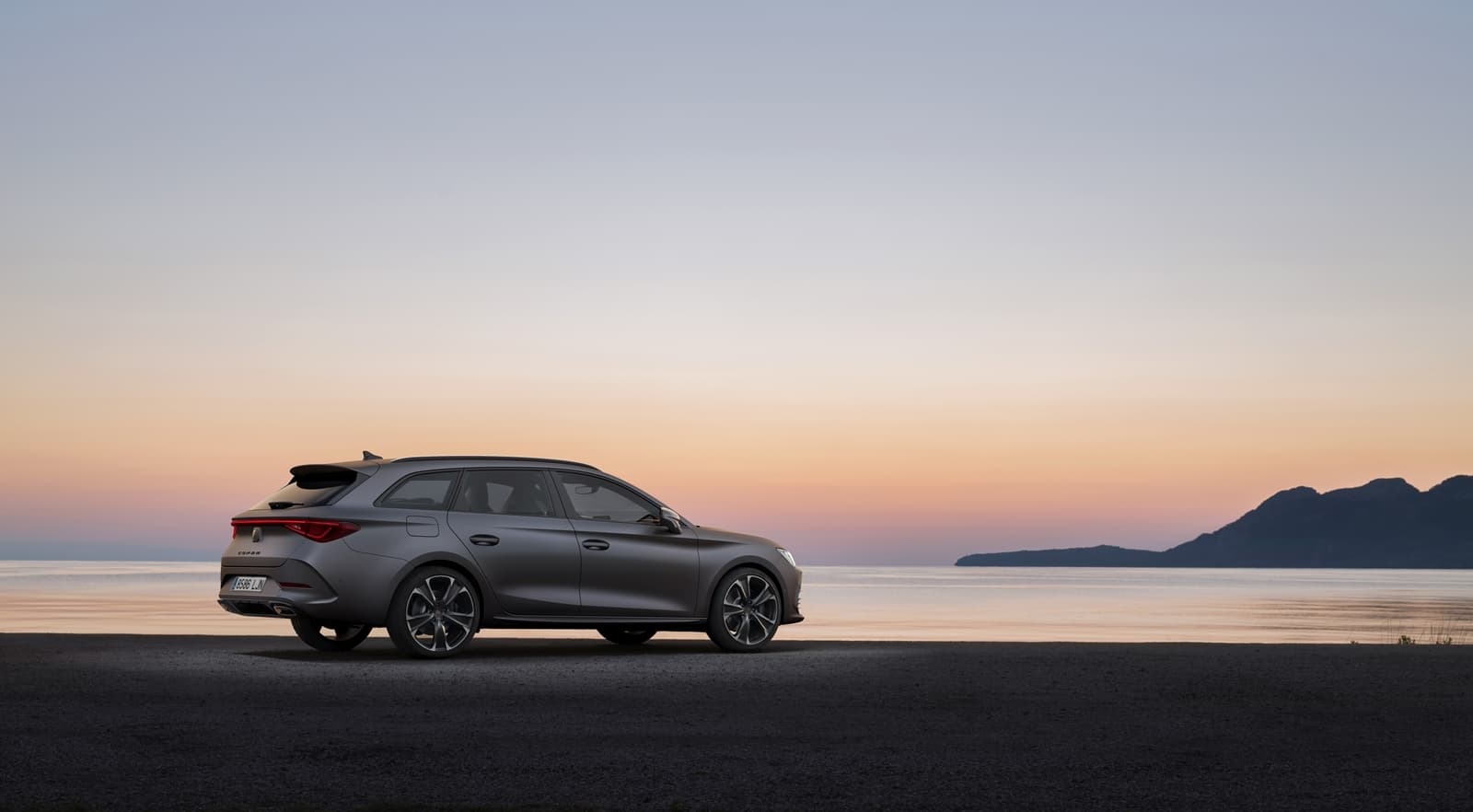 Vista lateral del CUPRA León con atardecer de fondo