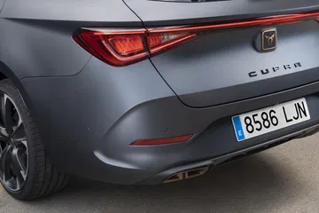 Vista dinámica de la trasera y lateral del CUPRA León, destacando su diseño deportivo.