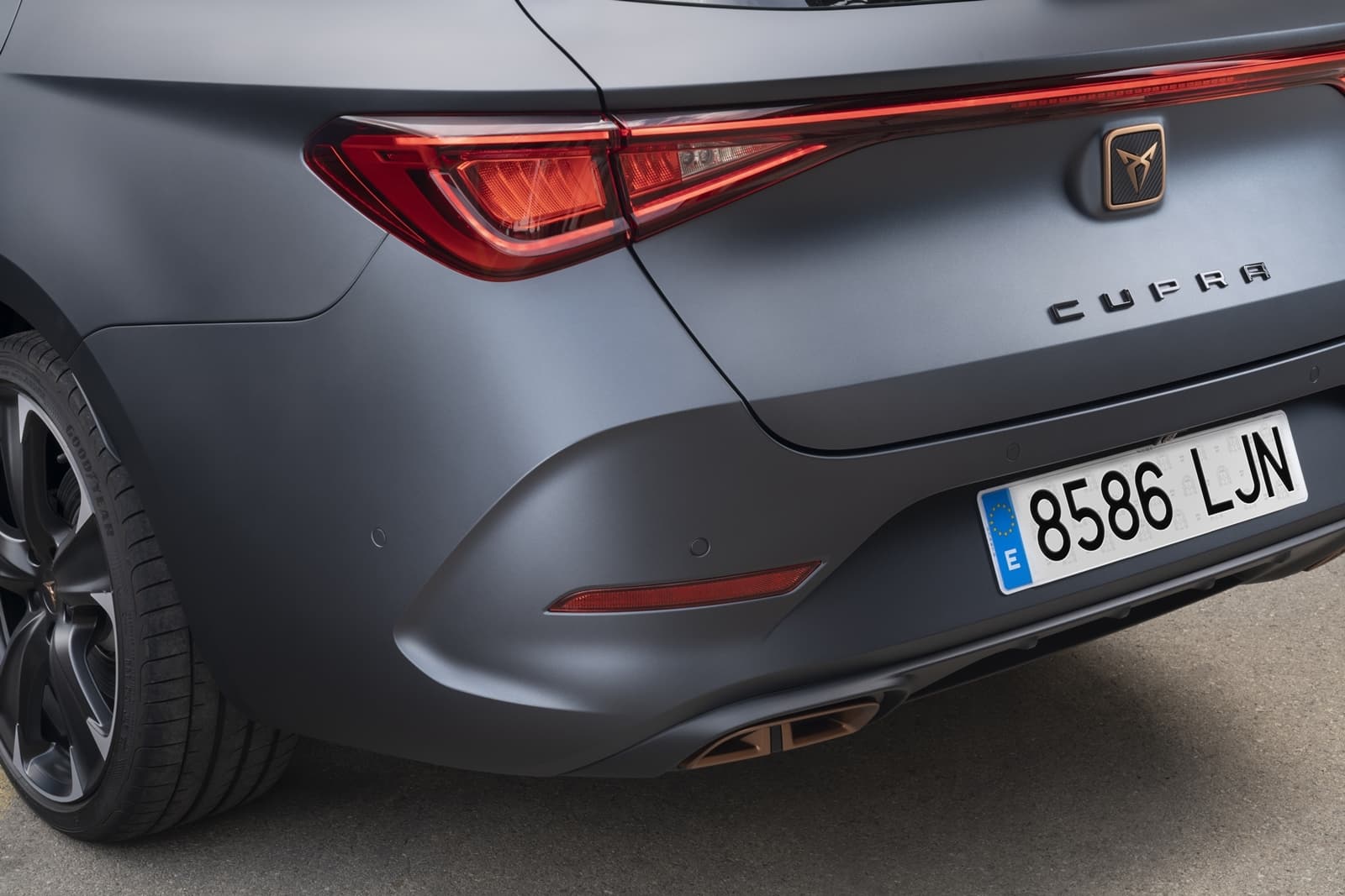 Vista dinámica de la trasera y lateral del CUPRA León, destacando su diseño deportivo.