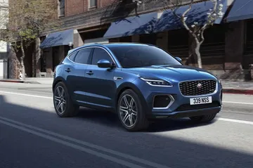 Vista dinámica de un Jaguar E-PACE en azul, perfil delantero lateral en ciudad.