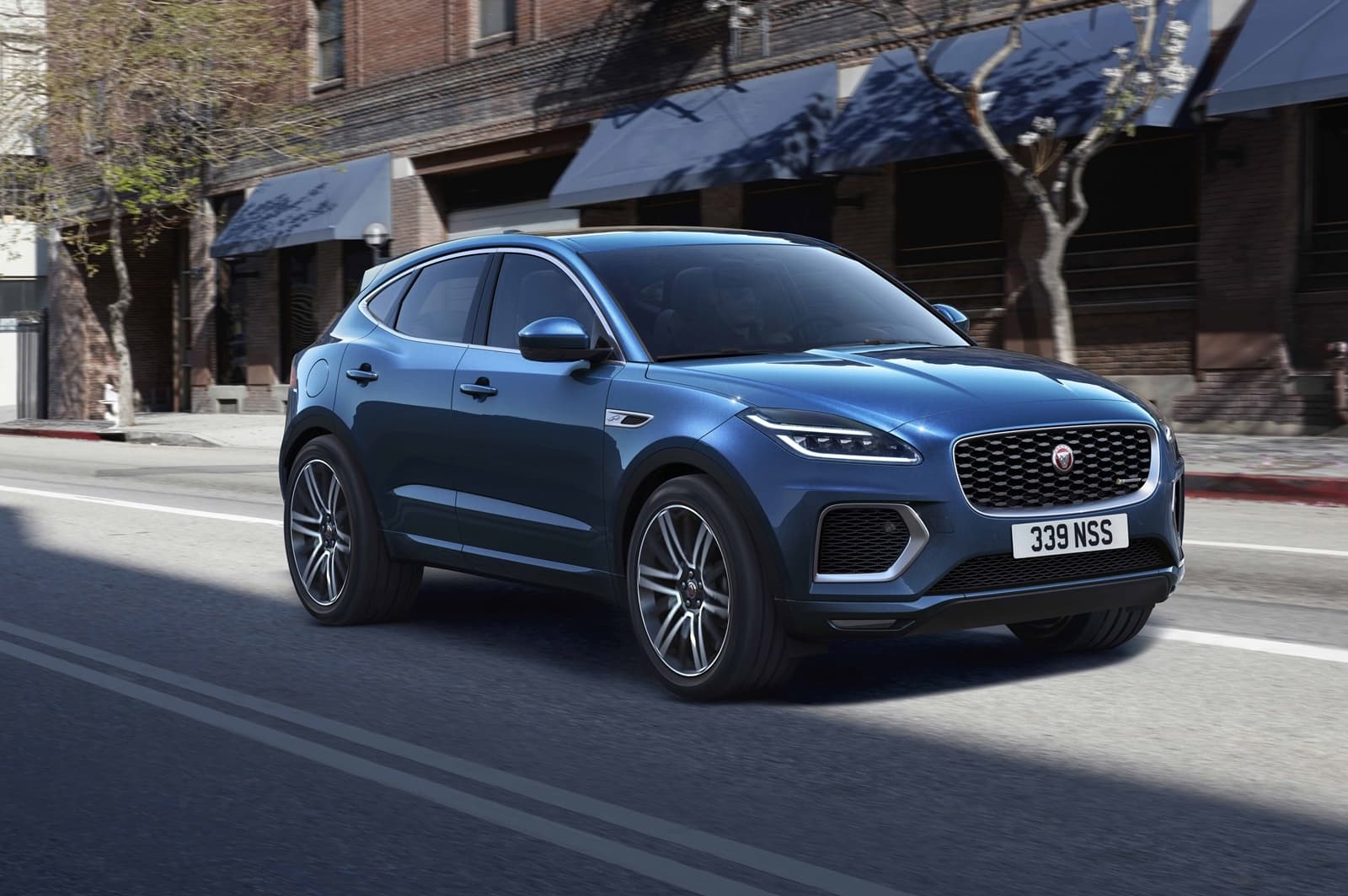 Vista dinámica de un Jaguar E-PACE en azul, perfil delantero lateral en ciudad.