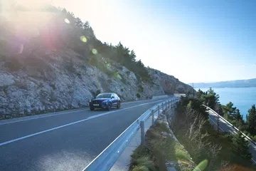 Jaguar E-PACE en carretera costera, reflejando agilidad y performance.