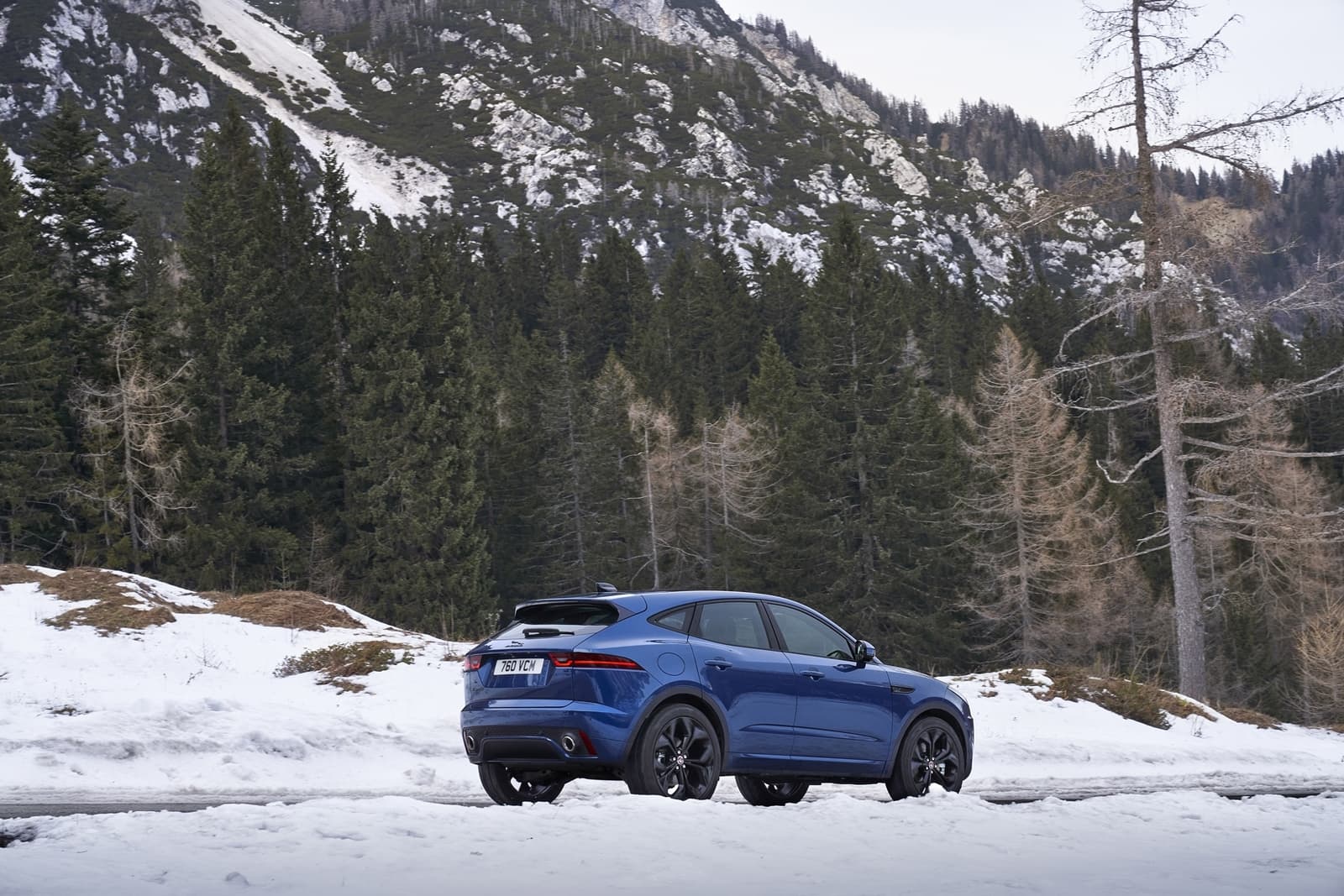 Vista lateral del Jaguar E-PACE en un entorno nevado, mostrando su diseño y línea.
