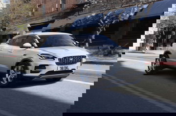 Vista lateral del Jaguar E-PACE rodando en entorno urbano.