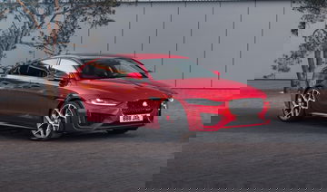 Vista lateral que muestra el dinámico perfil del Jaguar XE en color rojo.