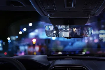 Visión nocturna a través del espejo retrovisor, destacando iluminación y claridad.