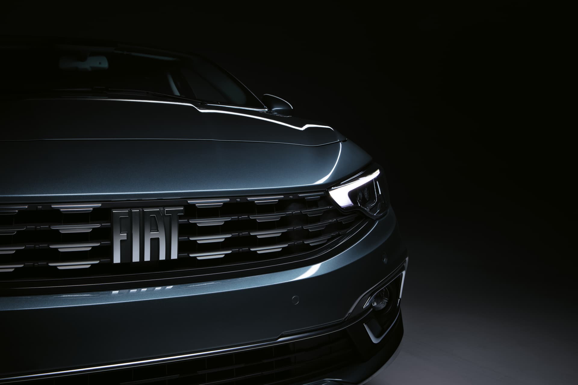 Vista parcial de la parrilla y emblema del Fiat Tipo, iluminación sutil.