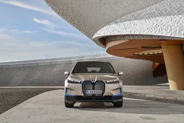 Vista frontal del BMW iX destacando su imponente parrilla y faros LED.