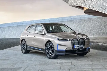 Vista angular del BMW iX que destaca su silueta aerodinámica y frontal agresivo.