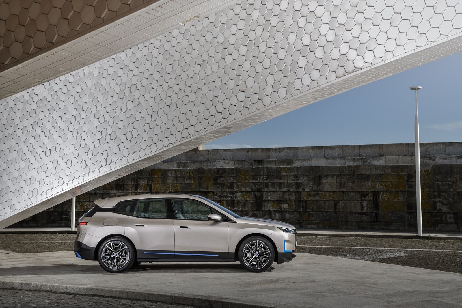 Vista lateral del BMW iX destacando su diseño aerodinámico y modernas llantas.