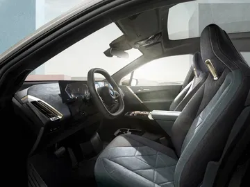 Vista lateral de la cabina del BMW iX destacando diseño y tecnología.